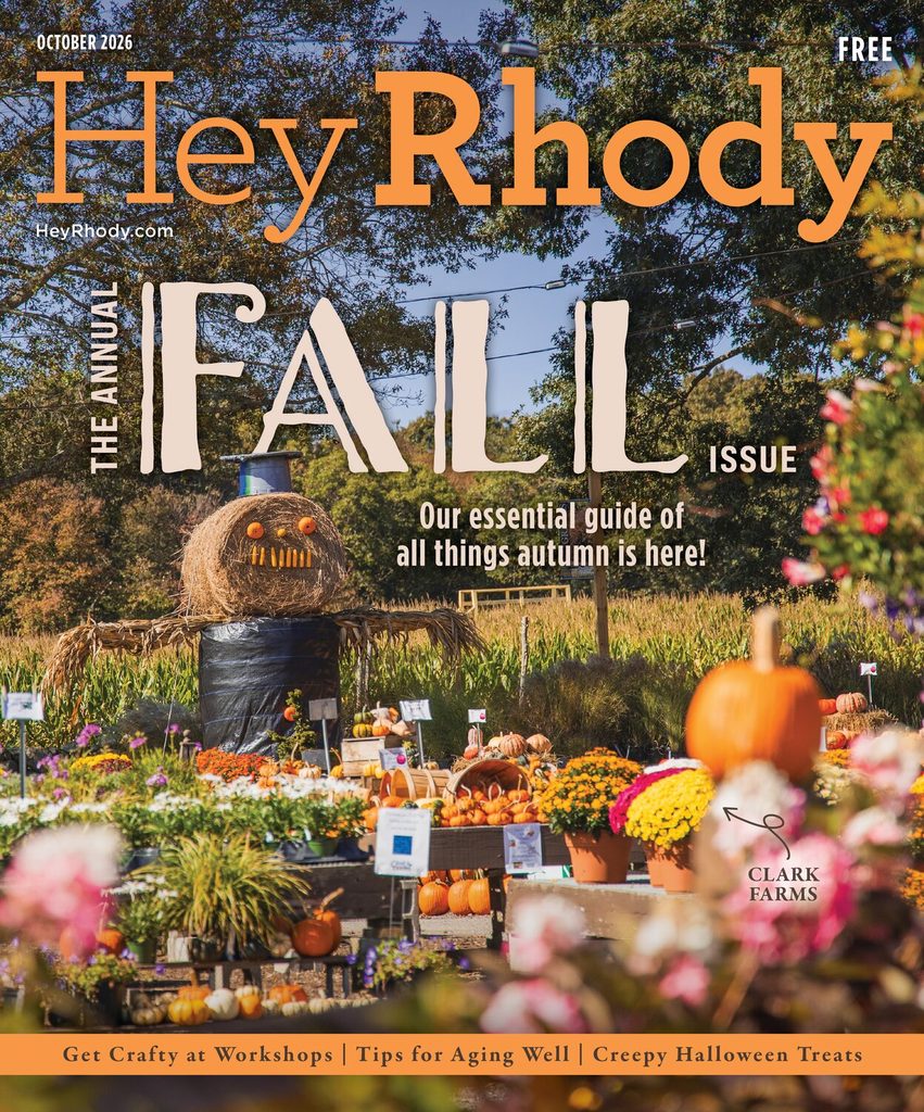 Cover of the Hey Rhody Fall Issue featuring a pumpkin and hay bale display with autumn flowers at a farm festival.